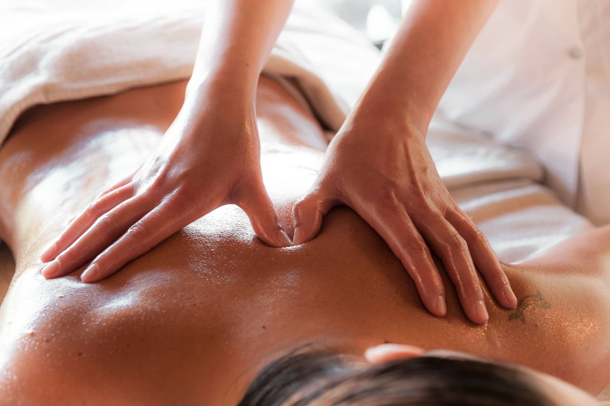 Massothérapeute réalisant un massage relaxant du dos.